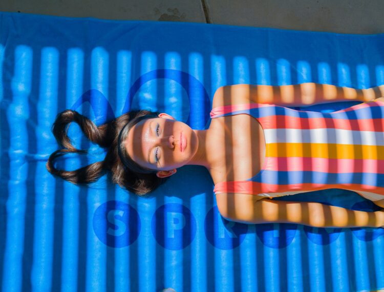 woman wearing swimsuit lying on towel