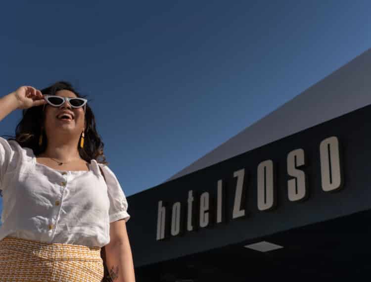 Girl in sunglasses smiling at entrance