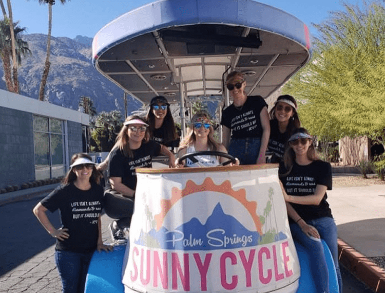 group posing in front of Sunny Cycle