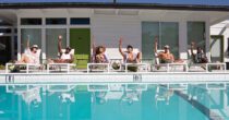 Guests raising their glasses by the pool