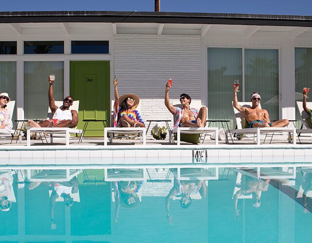 Guests raising their glasses by the pool