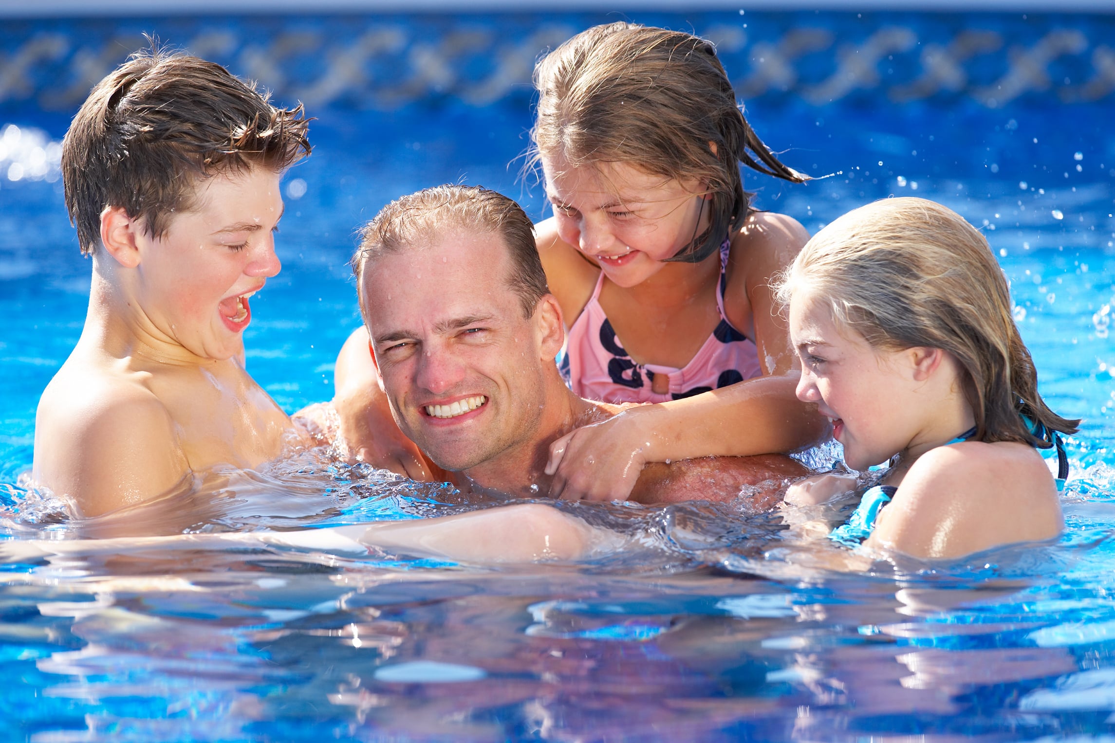 Father and children in swimming pool family