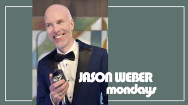A smiling person with a shaved head wearing a tuxedo with a blue velvet jacket and bow tie, holding a microphone. There's text overlay on the image that reads "JASON WEBER mondays". The background features a geometric pattern and a set of green vertical lines to the left.