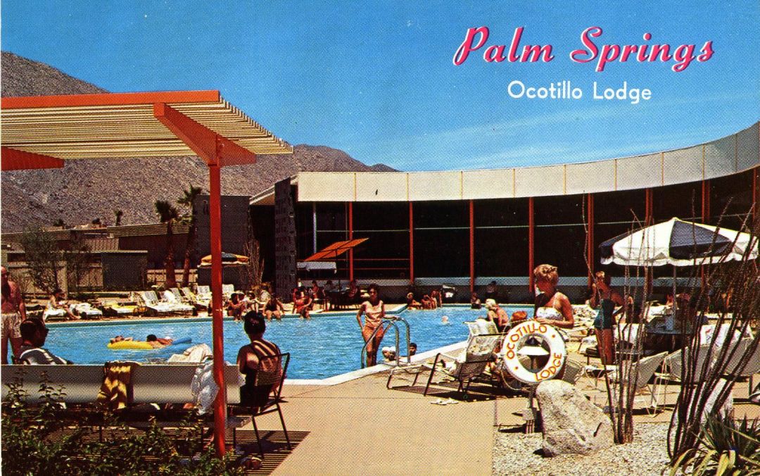 A vintage postcard of Palm Springs Ocotillo Lodge featuring people enjoying a sunny day around a large outdoor swimming pool, with mountains in the background, mid-century modern architecture, and a clear blue sky.