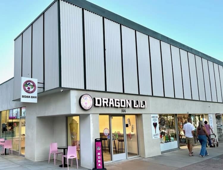 A two-story building with signage for "DRAGON LILI" and "BOBA BAR" on the first floor, pink tables outside, and several pedestrians walking by.
