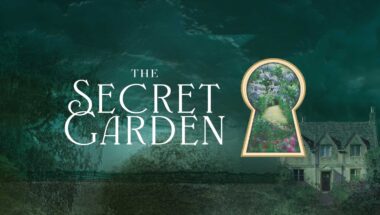 Promotional image for "The Secret Garden" with a dark green, foliage-filled background, overlaid by the title in stylized white script. A keyhole shape is cut out of the scenery revealing a bright garden pathway, opposite to a dimly lit, old stone house on the right.